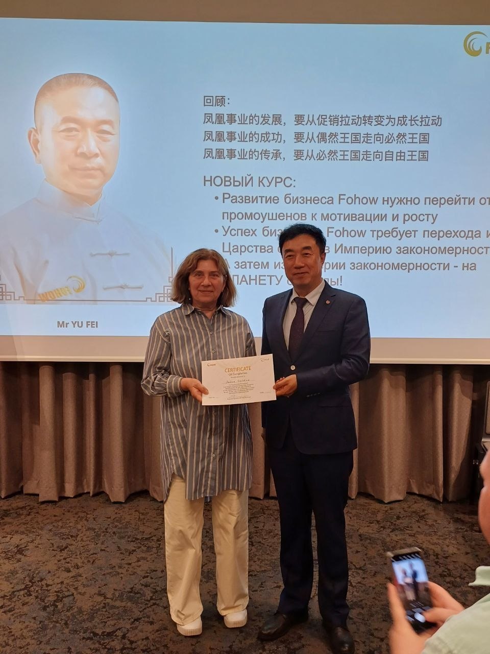 Галина получает сертификат от представителя компании Fohow
